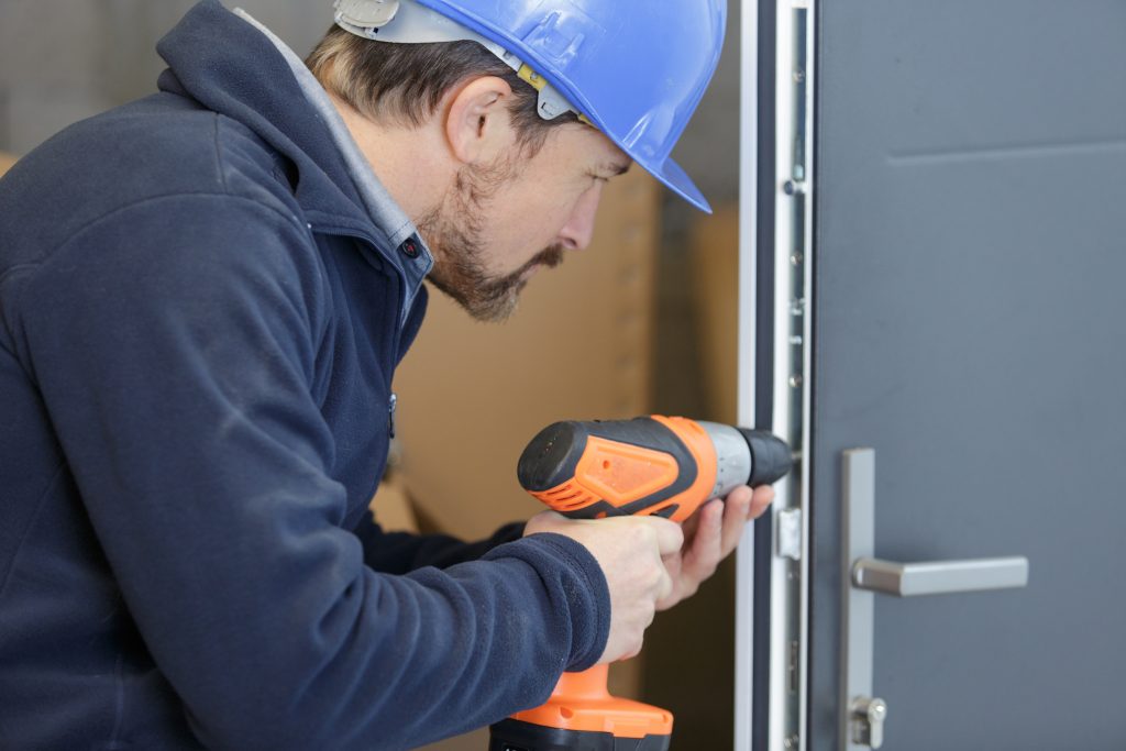 man drills a hole in a door