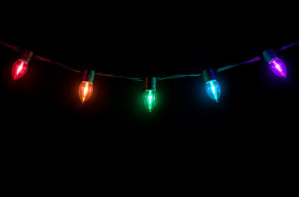 Multicolored garland lights hanging on dark background